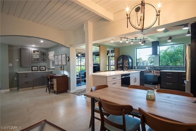 interior space featuring beam ceiling, sink, rail lighting, and a wealth of natural light