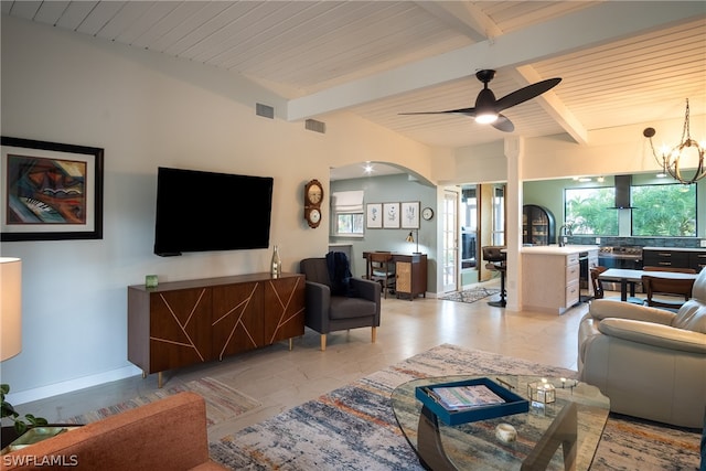 living room with light tile flooring, beamed ceiling, and ceiling fan with notable chandelier