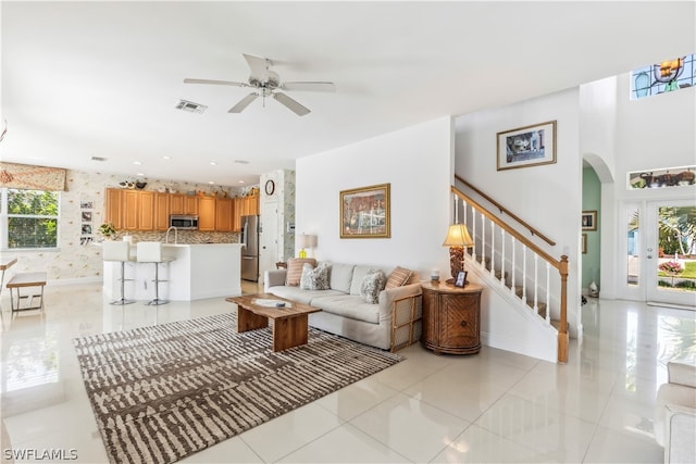 living room with ceiling fan, light tile floors, and a wealth of natural light