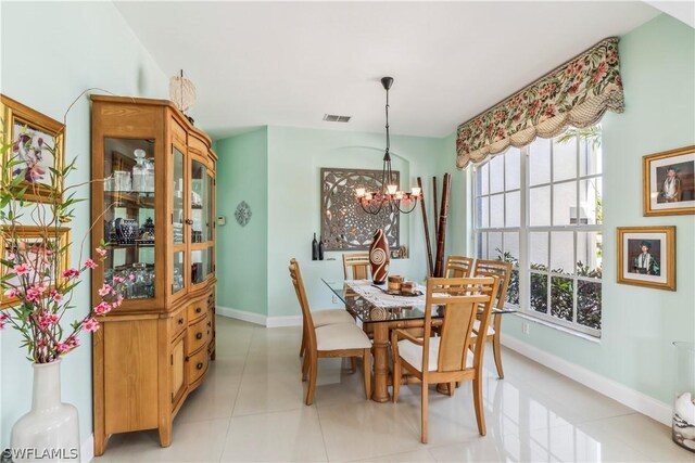 tiled dining area featuring a chandelier