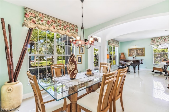 dining area featuring plenty of natural light, a notable chandelier, and light tile floors