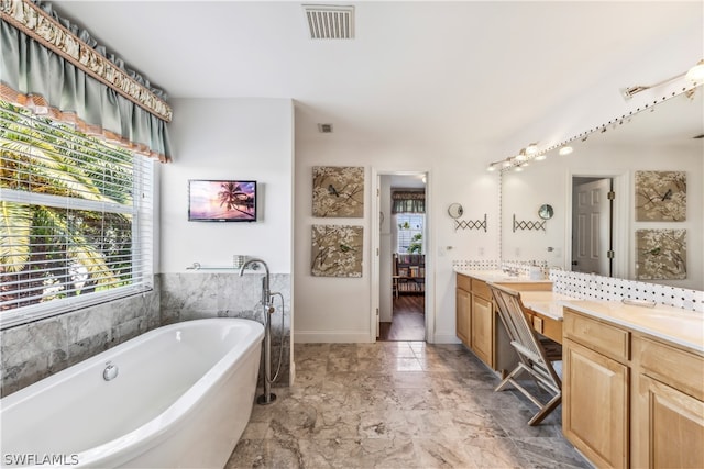 bathroom featuring a tub, tile floors, double sink, and large vanity