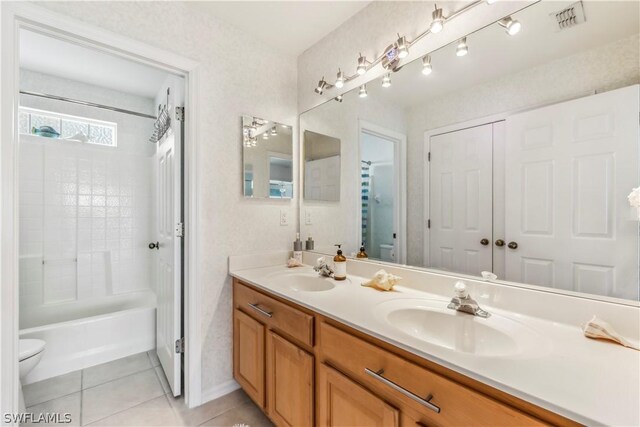 full bathroom featuring tile patterned flooring, vanity, bathtub / shower combination, and toilet