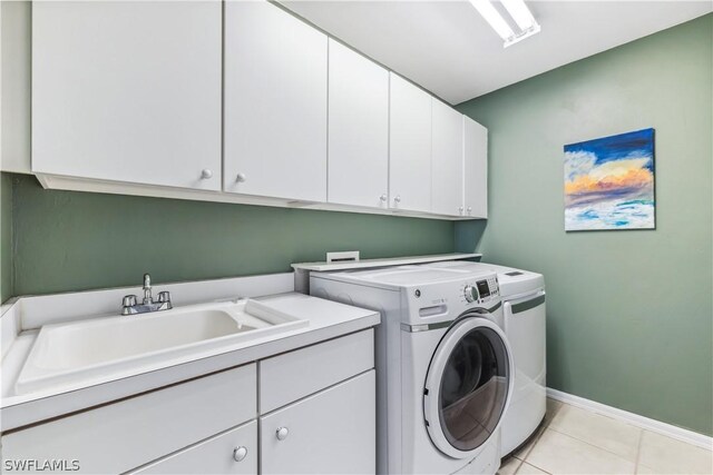 clothes washing area featuring cabinets, light tile patterned flooring, sink, and independent washer and dryer