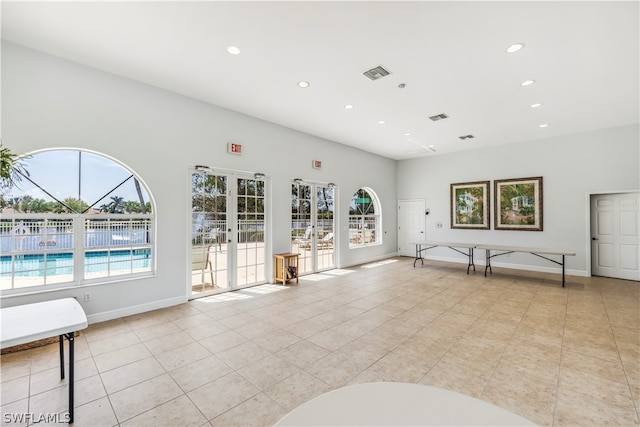 unfurnished living room with light tile floors and french doors