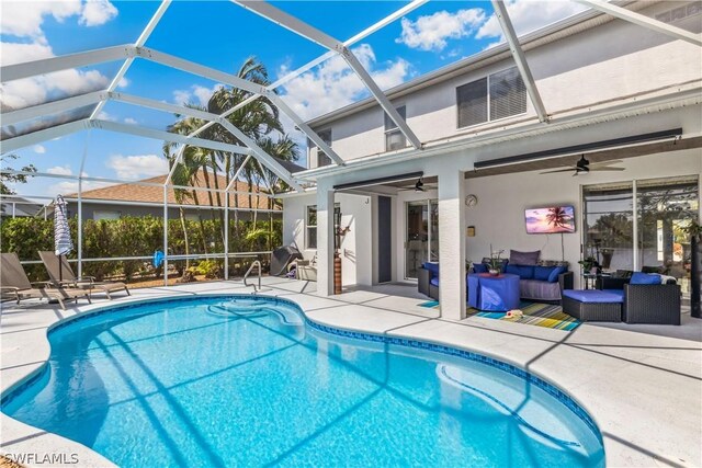 view of swimming pool with ceiling fan, a patio, outdoor lounge area, and glass enclosure