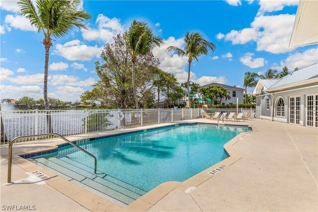 view of pool featuring a patio and a water view