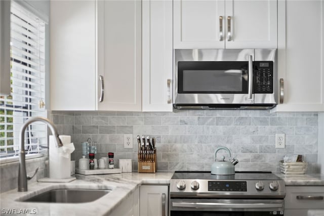 kitchen featuring stainless steel appliances, sink, and white cabinets