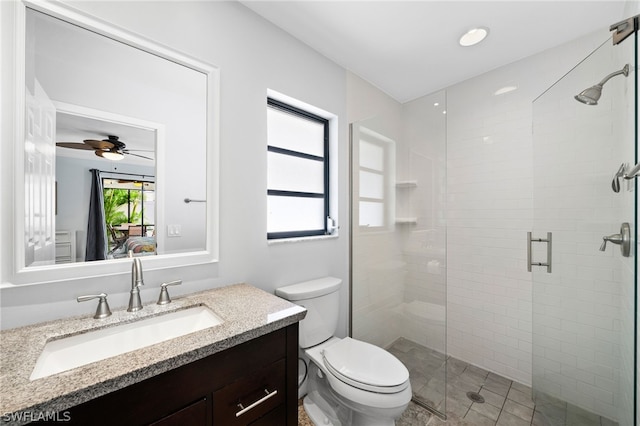 bathroom featuring walk in shower, ceiling fan, vanity, and toilet