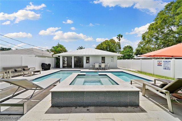 view of swimming pool featuring an in ground hot tub and a patio area