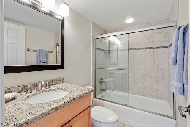 full bathroom featuring toilet, vanity, and bath / shower combo with glass door