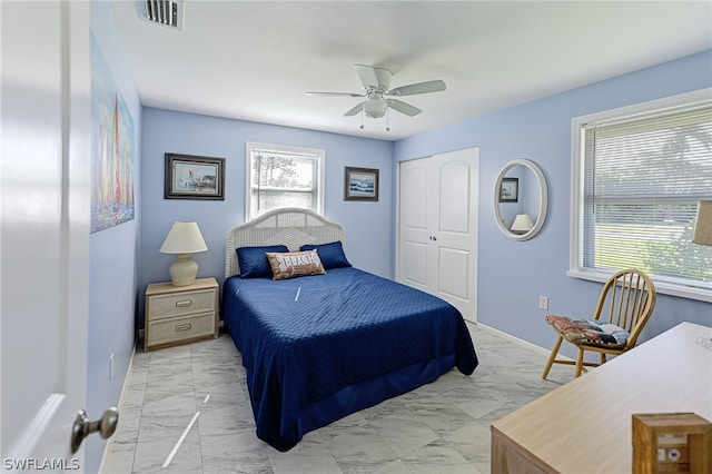 bedroom with a closet, multiple windows, ceiling fan, and light tile flooring