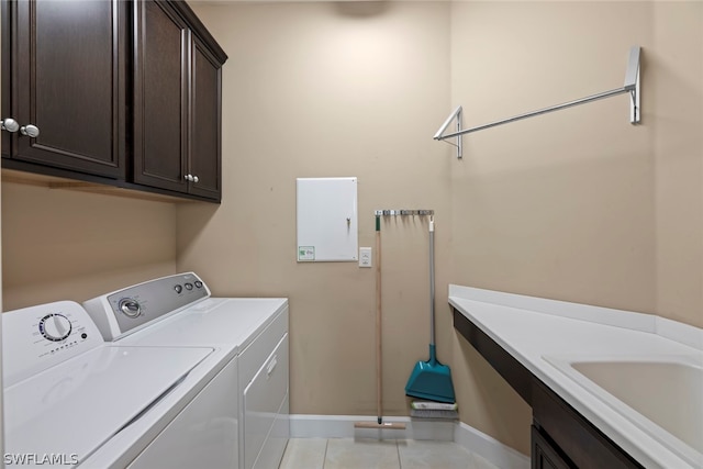 washroom with cabinets, independent washer and dryer, and light tile floors