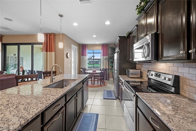 kitchen with sink, hanging light fixtures, stainless steel appliances, light tile flooring, and tasteful backsplash