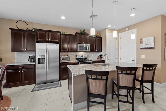 kitchen featuring backsplash, decorative light fixtures, appliances with stainless steel finishes, and sink