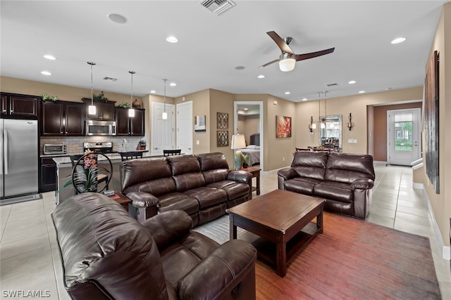 tiled living room featuring ceiling fan and sink