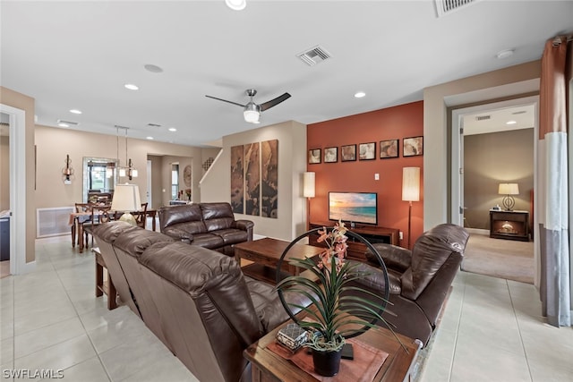 living room with ceiling fan with notable chandelier and light tile flooring