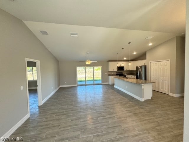 kitchen with high vaulted ceiling, ceiling fan, a wealth of natural light, and appliances with stainless steel finishes