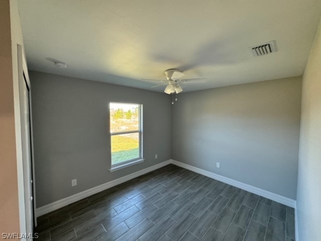 empty room featuring ceiling fan and dark wood-type flooring