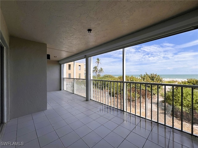 unfurnished sunroom featuring a water view