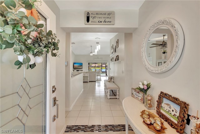 hallway with a chandelier and light tile patterned floors