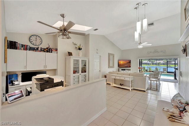 living room featuring light tile patterned floors, lofted ceiling with skylight, and ceiling fan