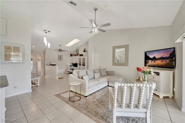 living room featuring light tile patterned floors, lofted ceiling with skylight, and ceiling fan