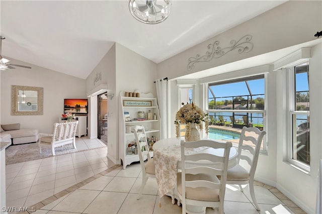 tiled dining area with ceiling fan and vaulted ceiling