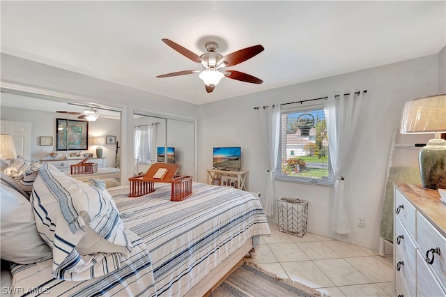 tiled bedroom with ceiling fan and a closet