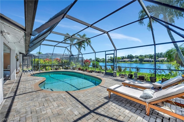 view of pool featuring glass enclosure, a patio area, and a water view