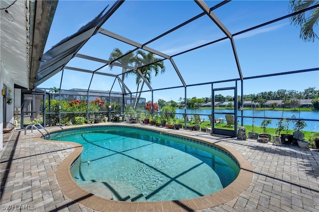 view of swimming pool with a patio area, a water view, and glass enclosure