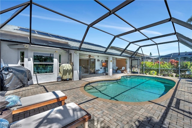 view of pool featuring ceiling fan, a lanai, a patio, and grilling area