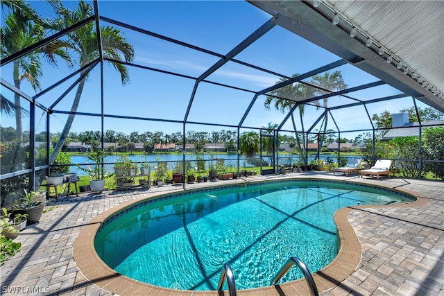 view of swimming pool featuring a patio, a water view, and glass enclosure