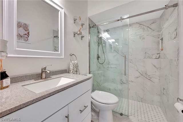 bathroom with vanity, toilet, and a shower with shower door