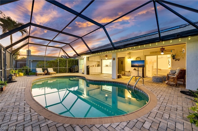 pool at dusk with a patio, ceiling fan, and a lanai