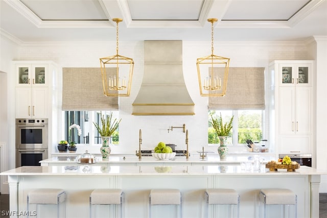 kitchen featuring white cabinetry, stainless steel double oven, a kitchen breakfast bar, and pendant lighting