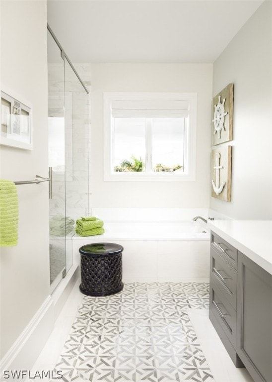 bathroom with tile patterned flooring, vanity, and plus walk in shower