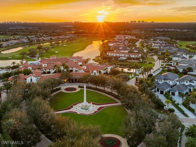 aerial view at dusk featuring a water view