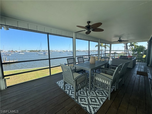 sunroom / solarium with a water view and ceiling fan