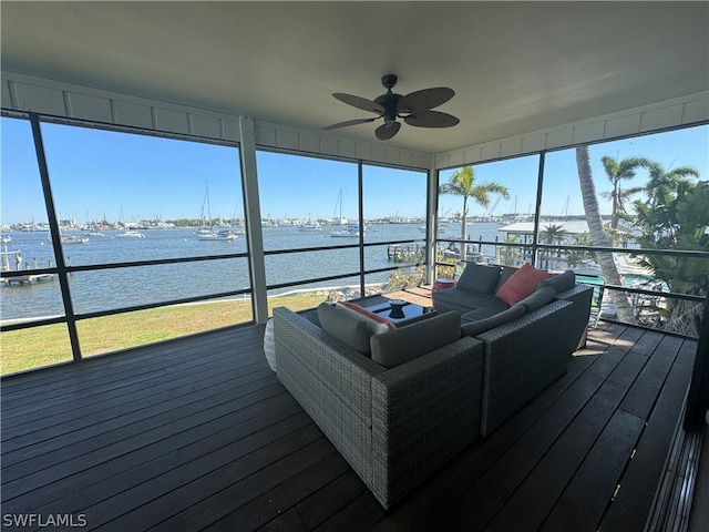 sunroom / solarium featuring a water view and ceiling fan