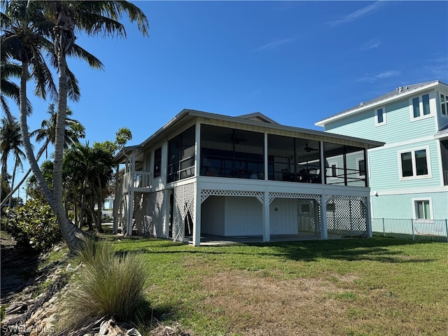 rear view of house with a sunroom and a yard