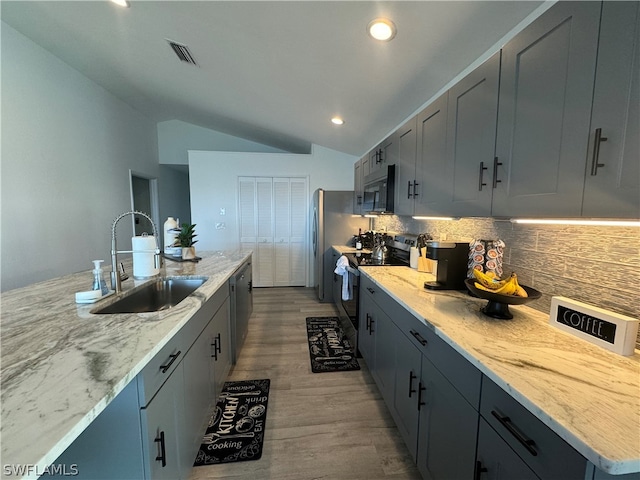 kitchen with electric stove, wood-type flooring, lofted ceiling, backsplash, and sink