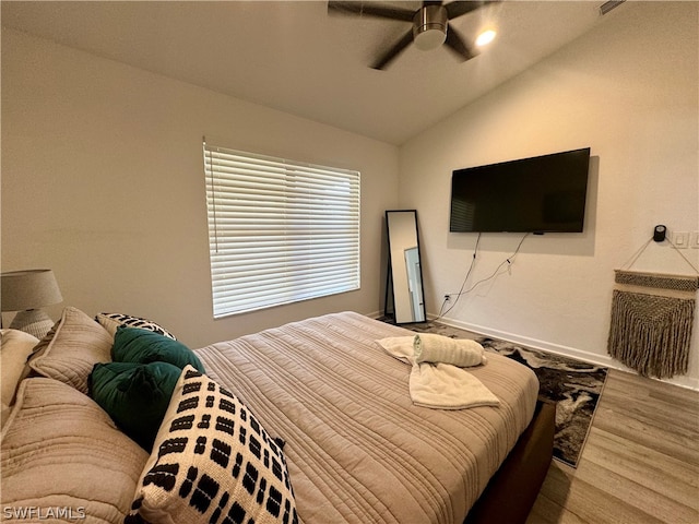 bedroom featuring hardwood / wood-style floors, vaulted ceiling, and ceiling fan