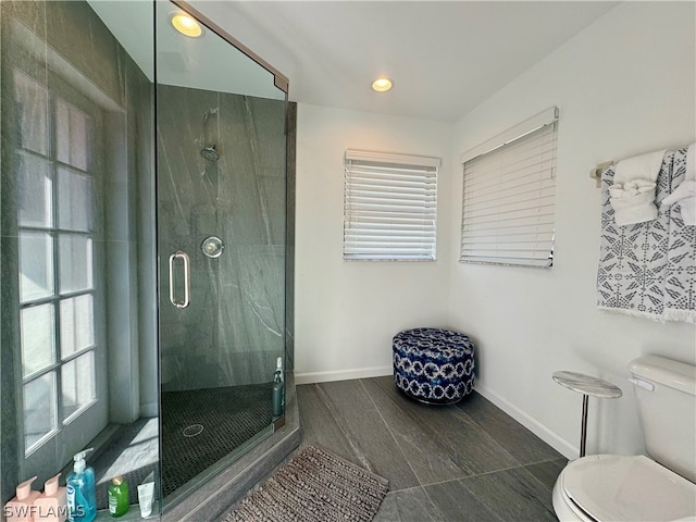 bathroom featuring toilet, a shower with shower door, and tile flooring