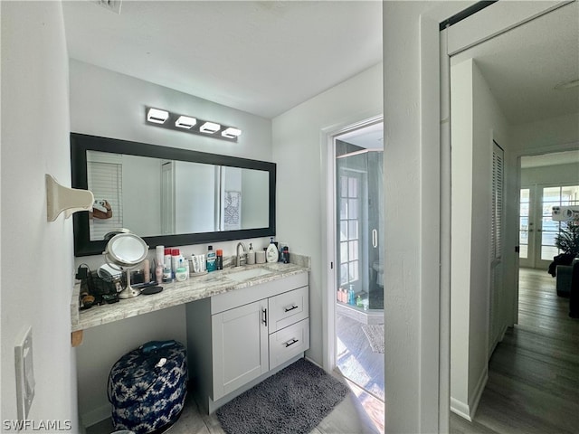 bathroom with hardwood / wood-style floors, vanity, and french doors