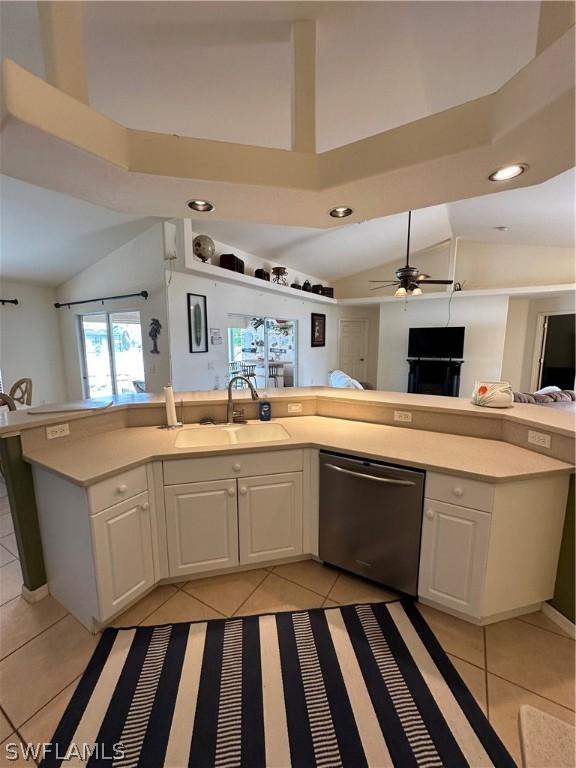 kitchen featuring white cabinets, light tile patterned floors, stainless steel dishwasher, and sink