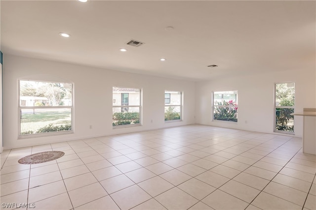 spare room featuring light tile floors and a wealth of natural light