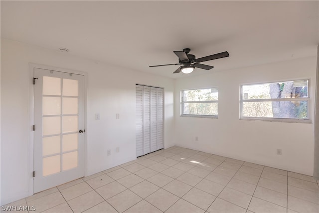 tiled spare room featuring ceiling fan