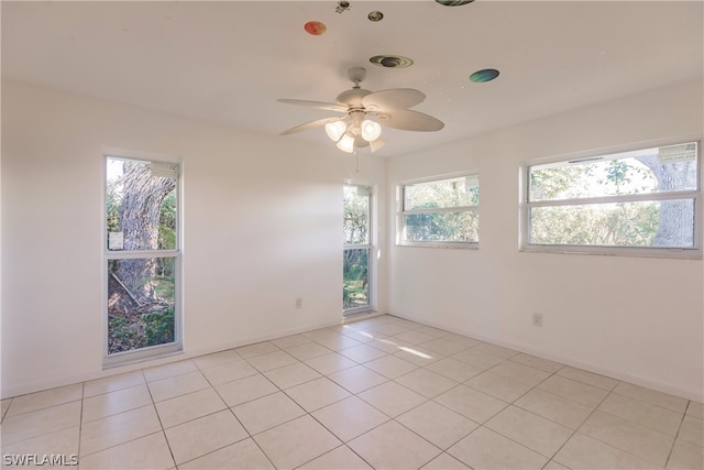 tiled empty room featuring ceiling fan