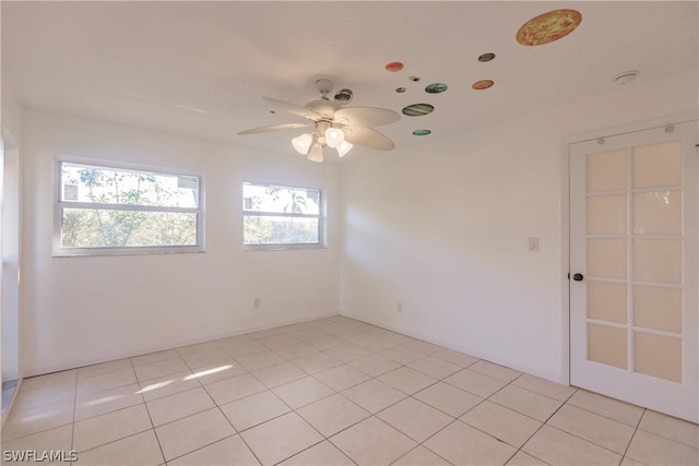 tiled spare room featuring ceiling fan